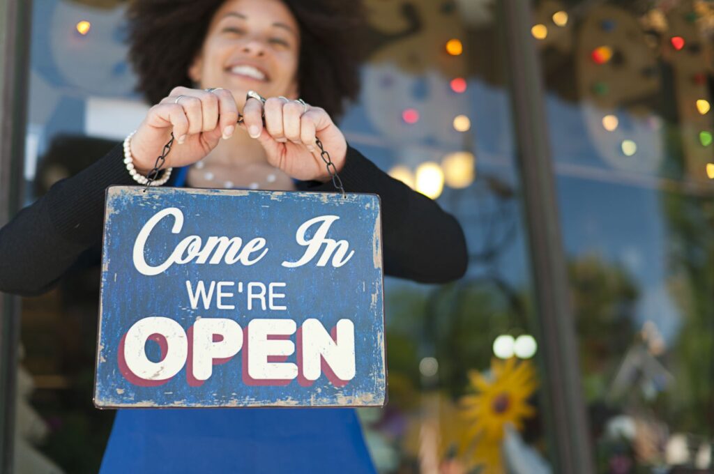 woman holding come in sign