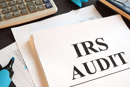 IRS Audit report and calculator on a desk