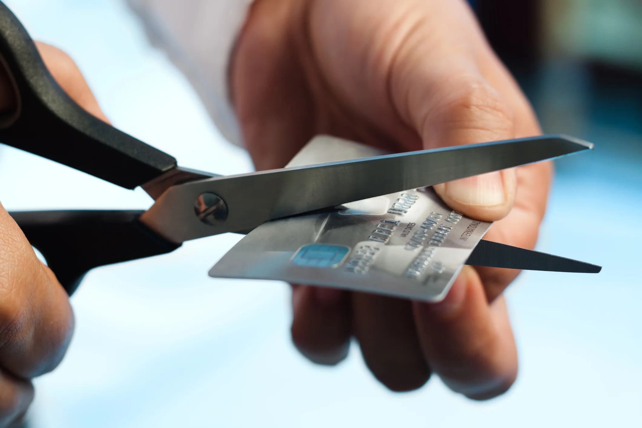 man closing credit card account and cutting it up